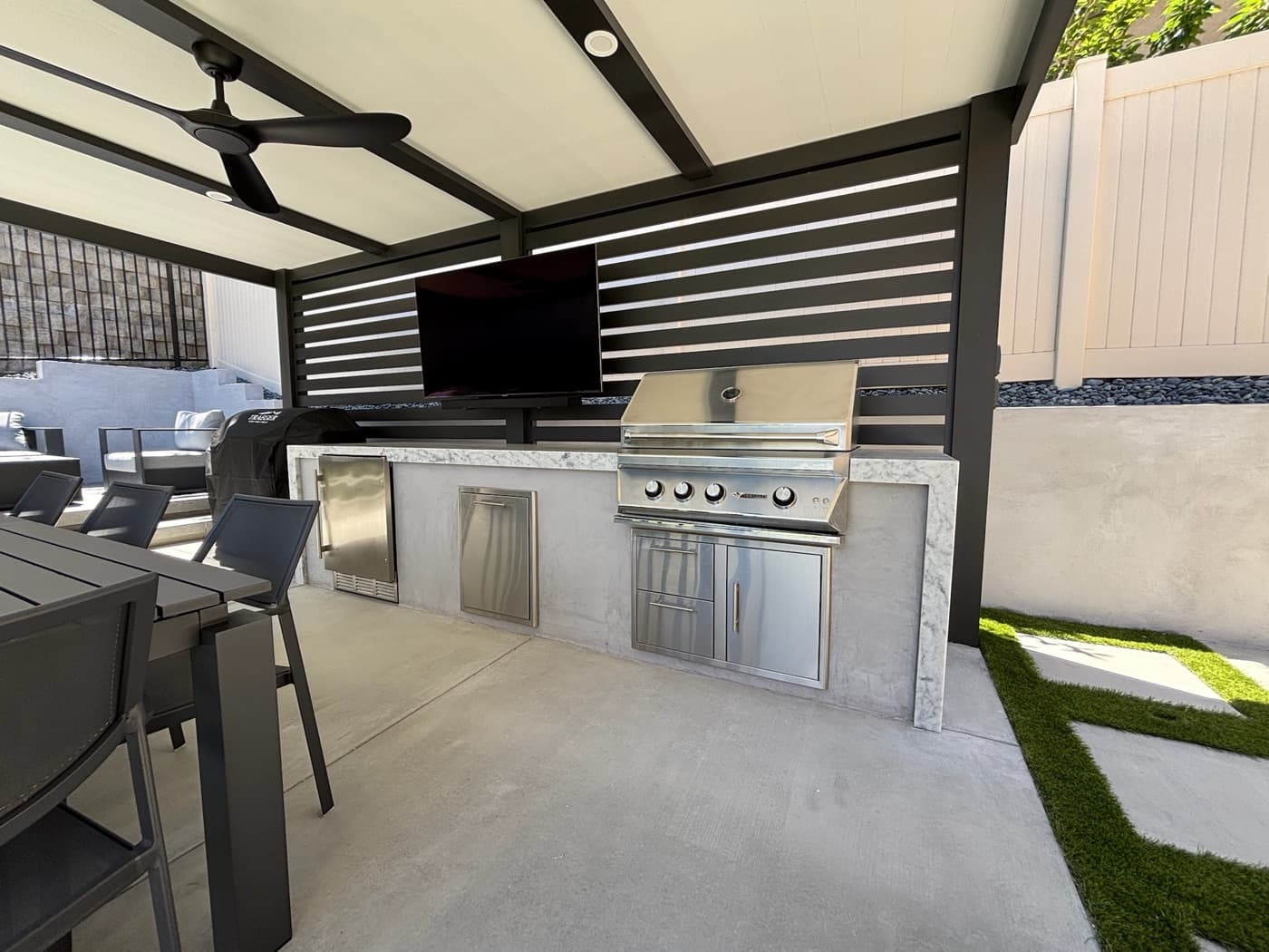Louvered outdoor kitchen with grill and TV in Carlsbad by Modern Yardz