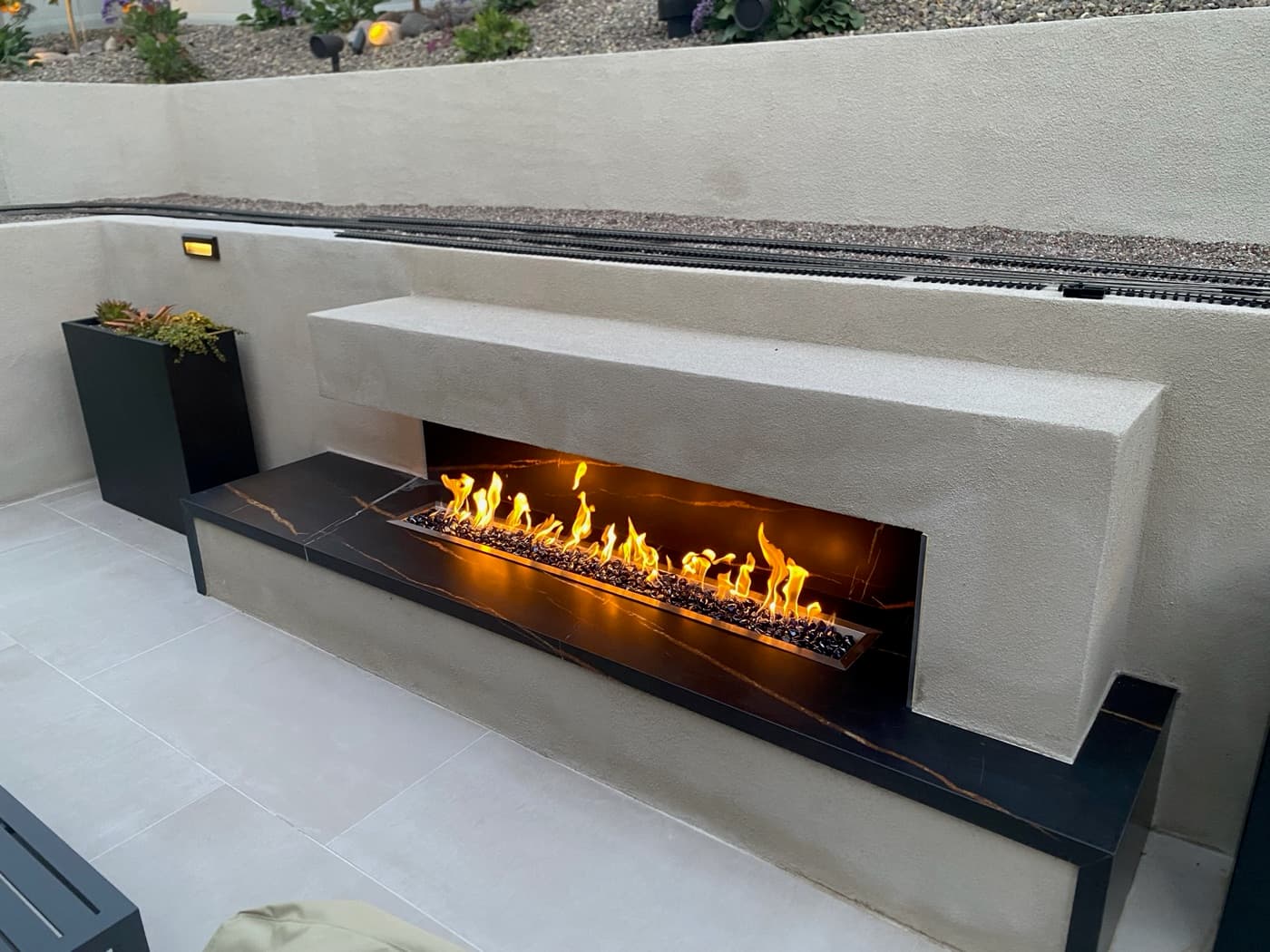 Linear fire feature with a porcelain surround in Carmel Valley by Modern Yardz