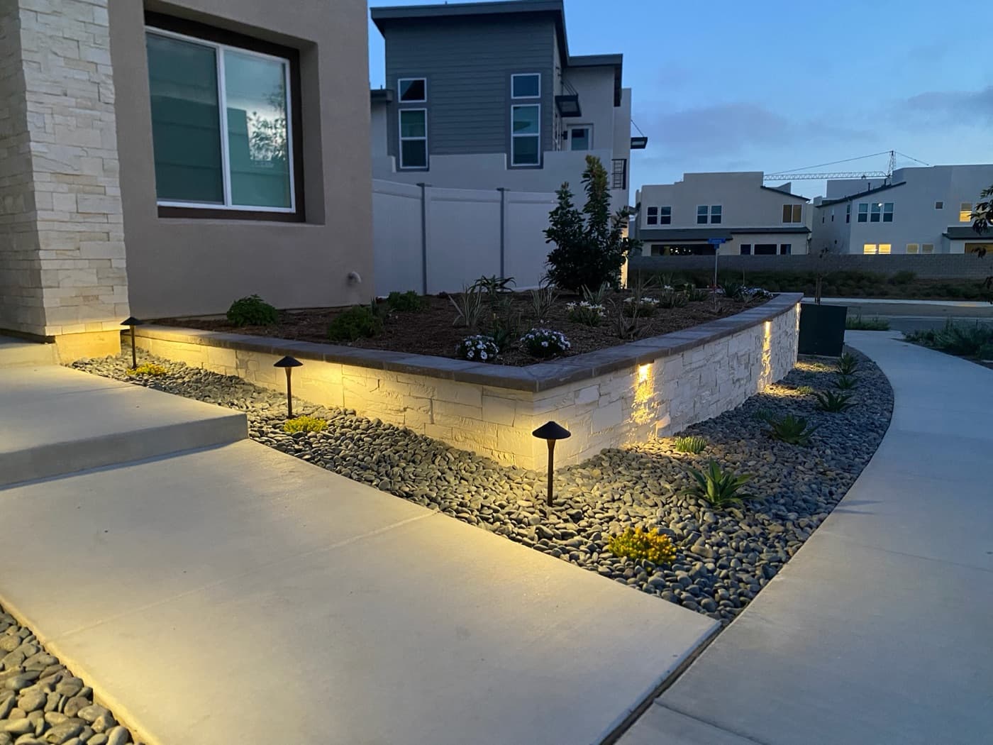 Front-yard planter wall with landscape lighting in Carmel Valley by Modern Yardz