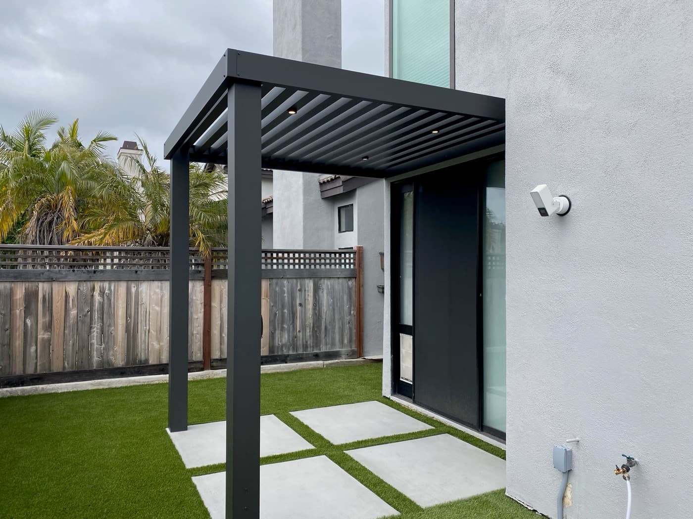 Louvered pergola over turf and pavers in Coronado by Modern Yardz
