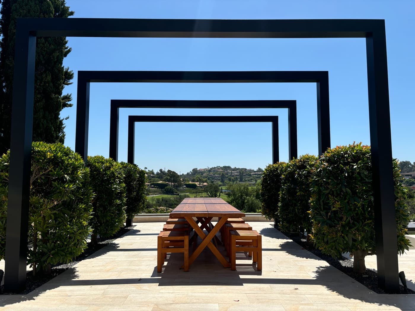 Steel arbor and outdoor dining terrace in Rancho Santa Fe by Modern Yardz