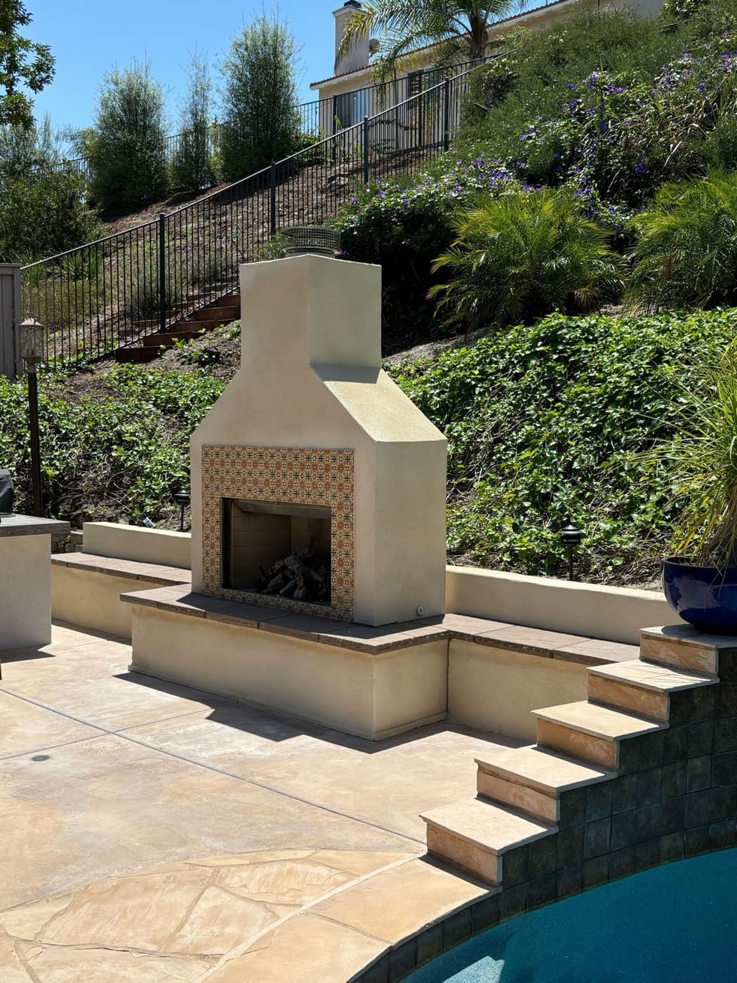 Outdoor fireplace on a hillside terrace in Rancho Santa Fe by Modern Yardz