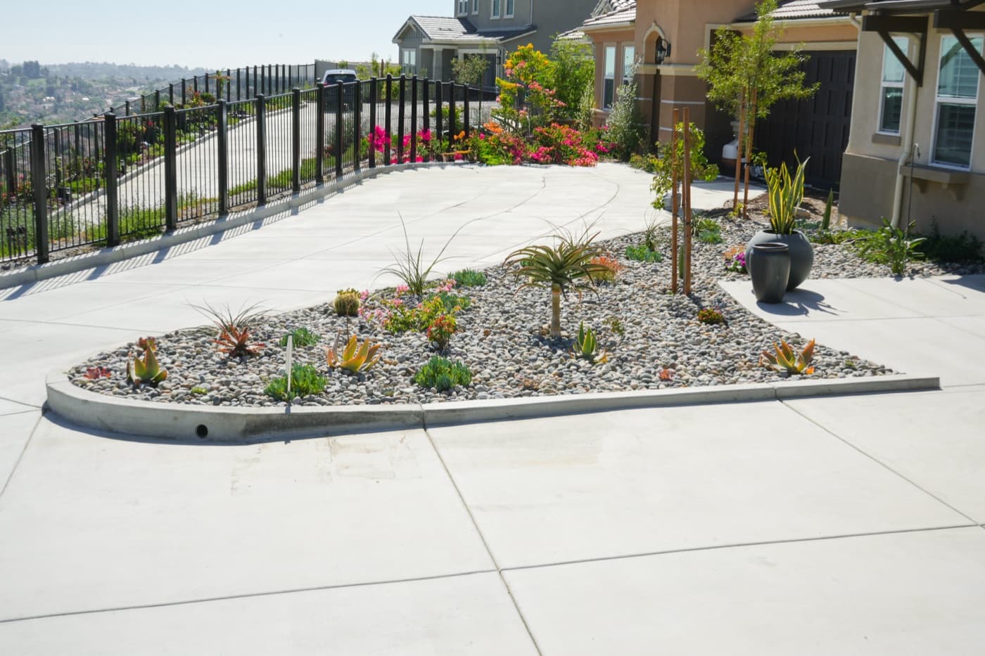 Drought-tolerant planted island in a concrete driveway built by Modern Yardz