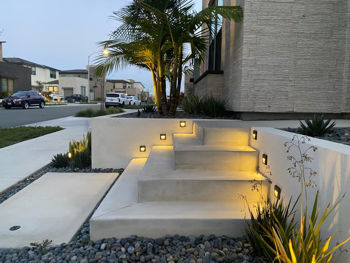 Lit entry steps and planter walls at a front entry built by Modern Yardz