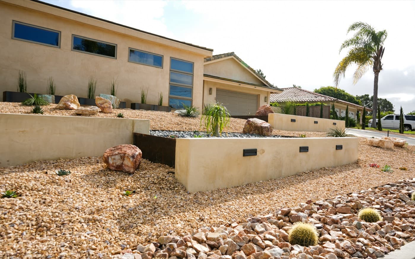 Drought-tolerant front yard with boulders, cactus, and terraced walls built by Modern Yardz