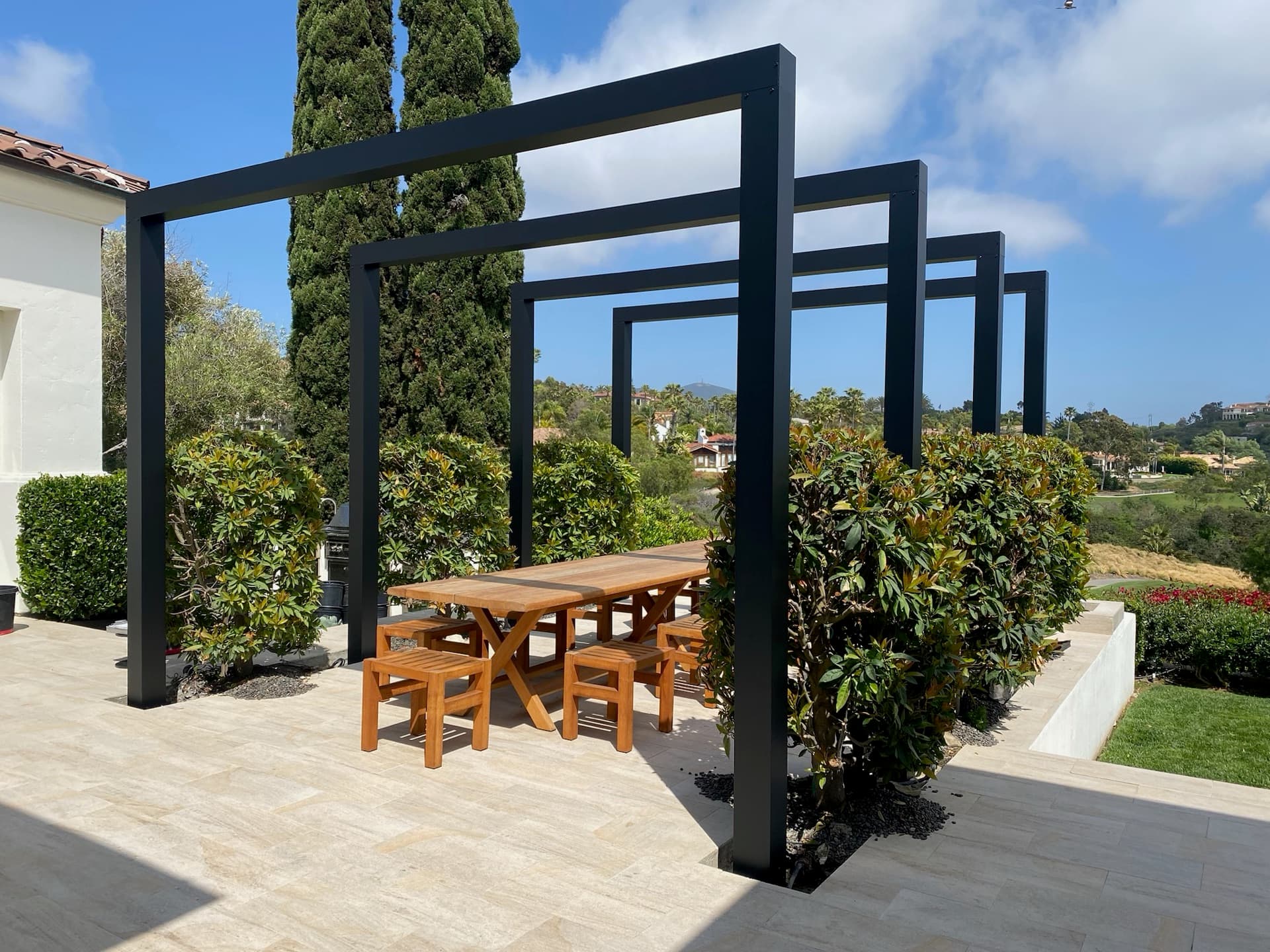Architectural steel arbor over an estate dining terrace, designed and built by Modern Yardz in Rancho Santa Fe, San Diego County