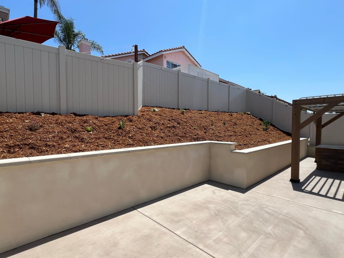 Terraced planting bed above a new stucco retaining wall by Modern Yardz San Diego