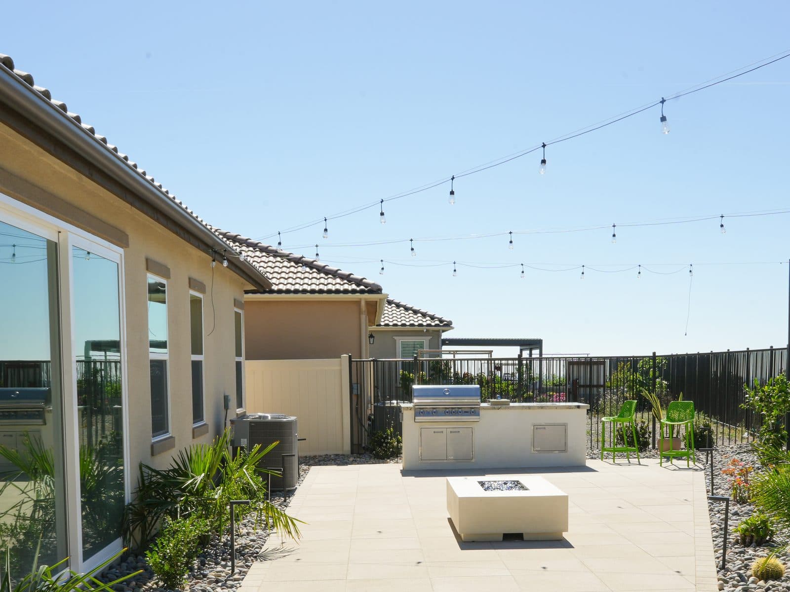 Large-format paver patio with outdoor kitchen and fire table in San Diego