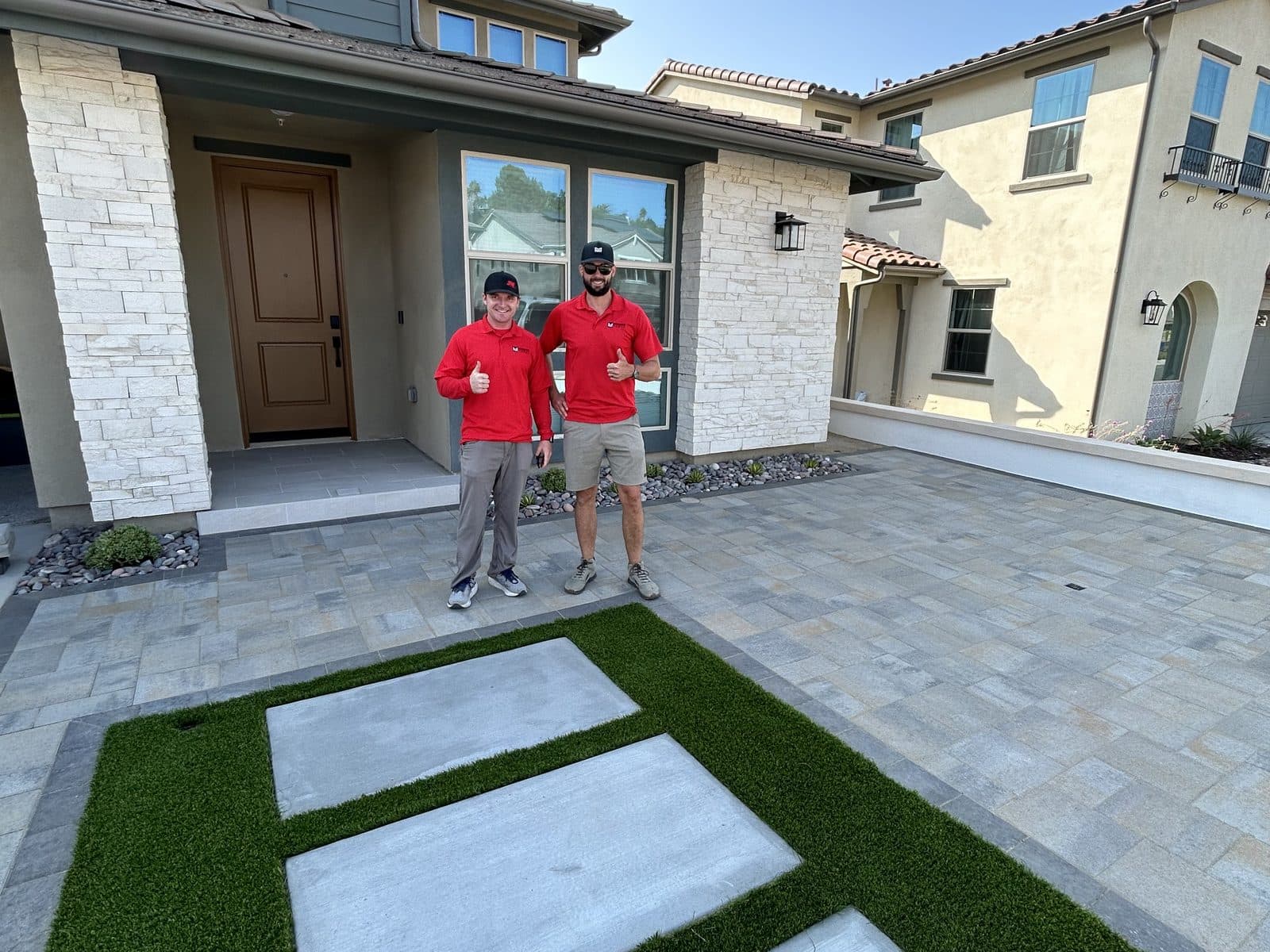 Front landscape with paver driveway, turf inlay and planted borders by Modern Yardz San Diego